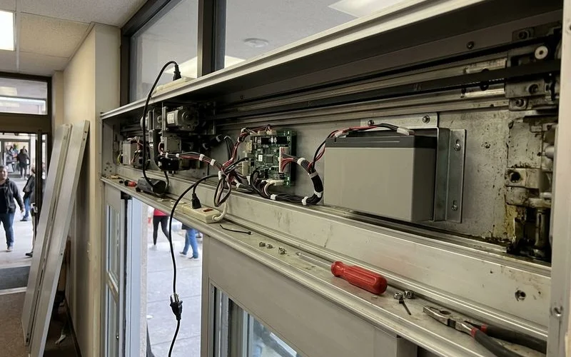 Backup battery unit inside a door header cabinet