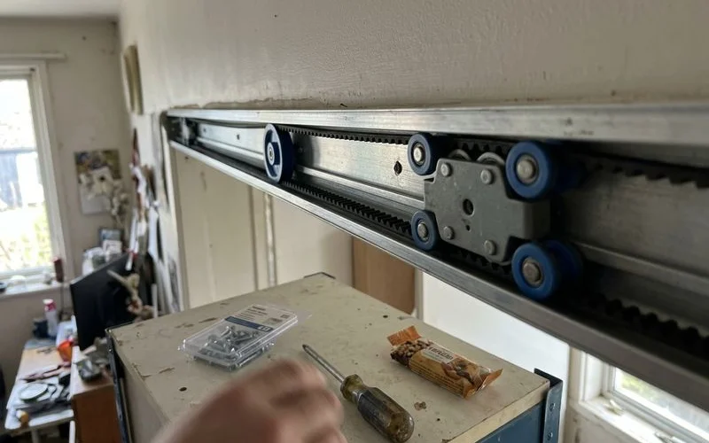 Sliding door track, roller carriage and belt inside the header rail