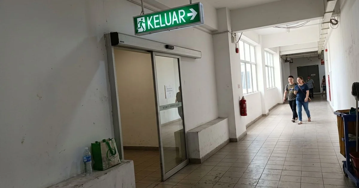 Emergency exit signage above an automatic breakout door in a Malaysian mall