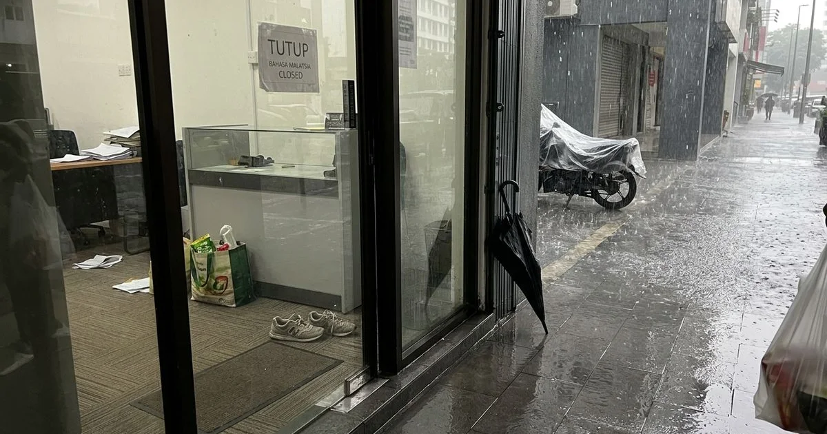 Monsoon rain outside a glass shopfront entrance in Malaysia