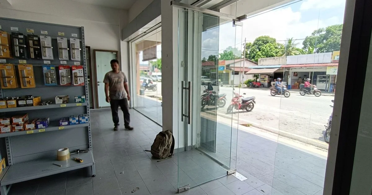 Large tempered glass door panel in a Malaysian showroom with sunlight through it