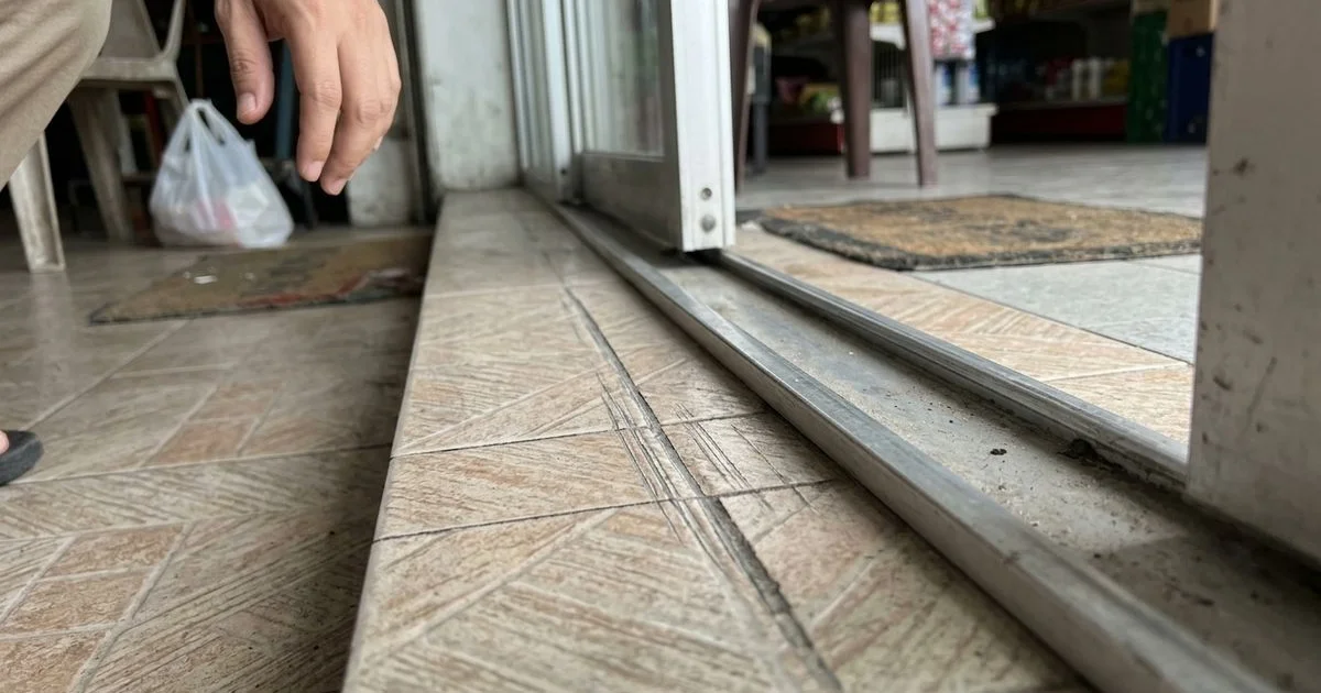 Sliding door leaf scraping a floor track with scuff marks visible