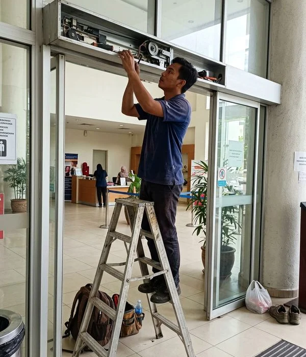 GW GeWalt technician adjusting an automatic sliding door mechanism
